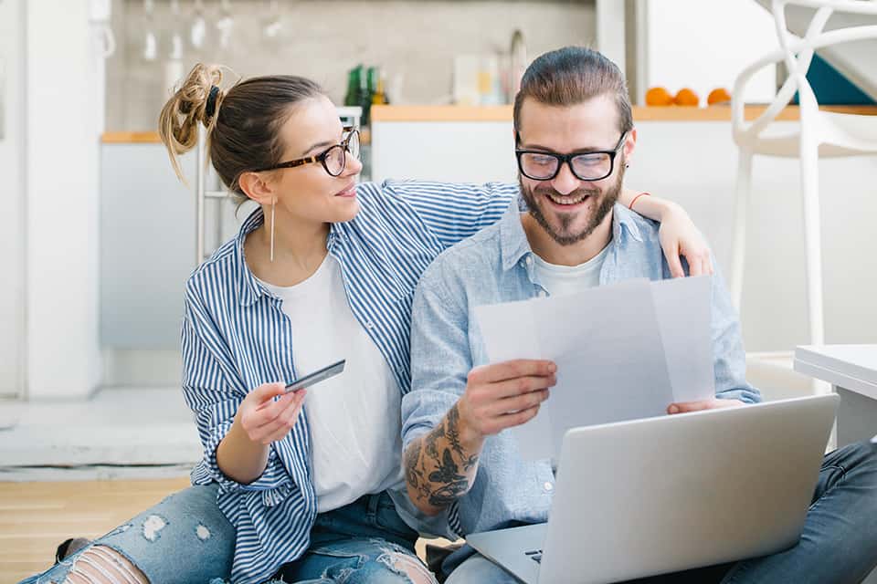 Couple holding laptop reviewing options